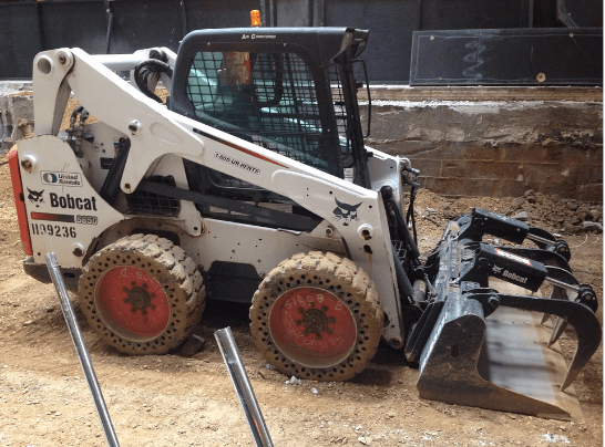 an image of a grapple bucket attached to a skid steer loader