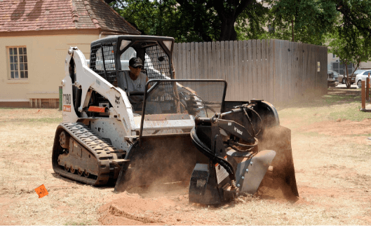 an image of a skid steer loader with a stump grinder attached