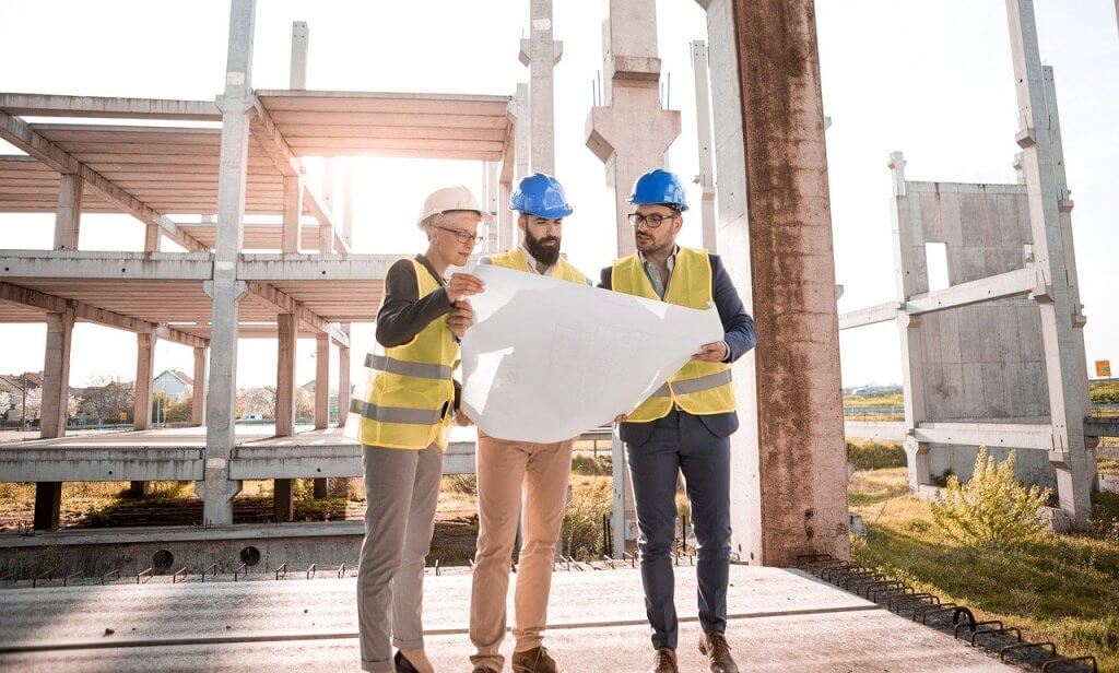 Image of three people looking at plans on a building site